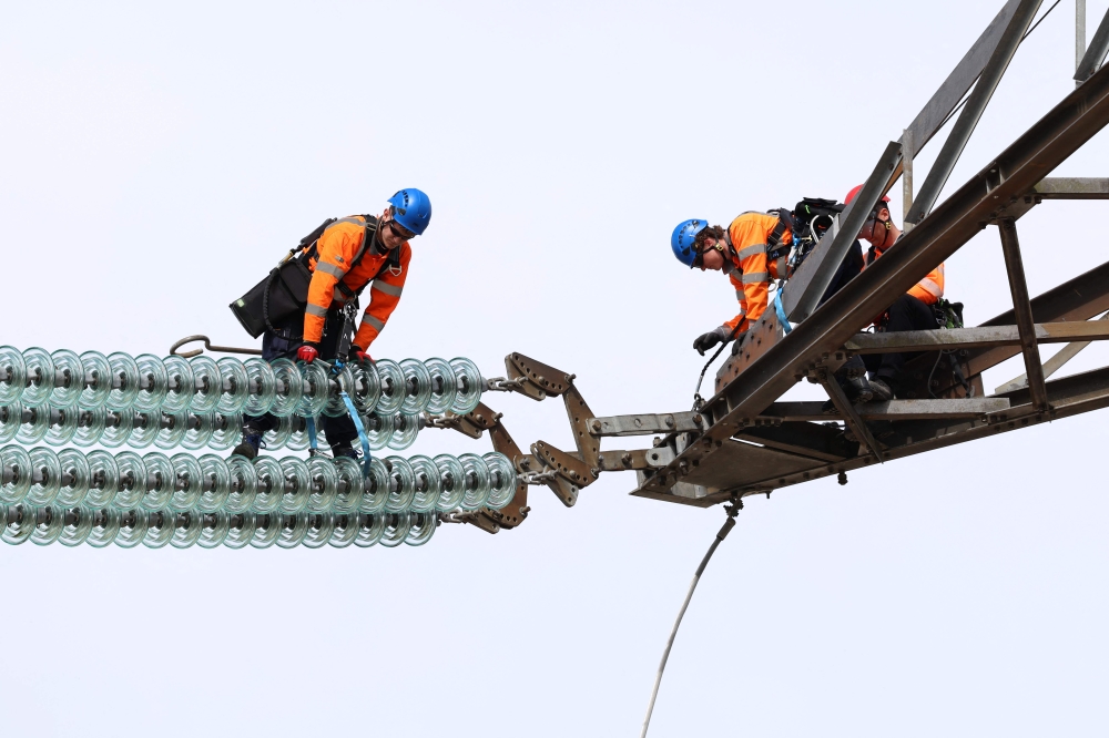 National Grid Overhead Line Apprentices train on a electricity pylon at the National Grid training centre in Eakring, central England April 28. — AFP pic